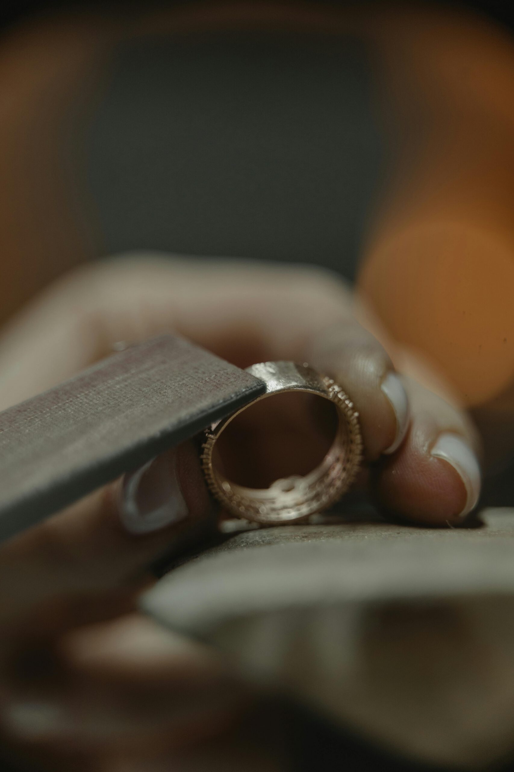 Close-up of a jeweler polishing a gold ring, showcasing craftsmanship.